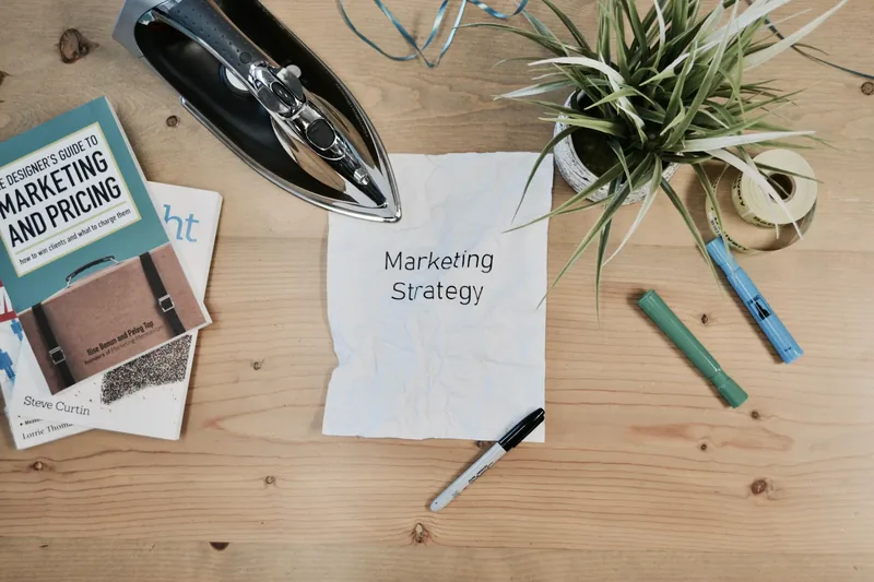Marketing strategy notes on a desk with a plant and stationery