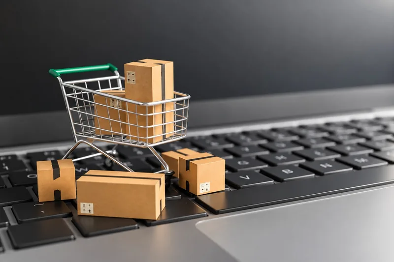 Shopping cart and parcels on a laptop keyboard