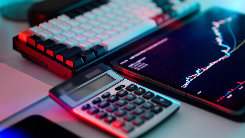 Calculator, keyboard and a phone showing a price chart