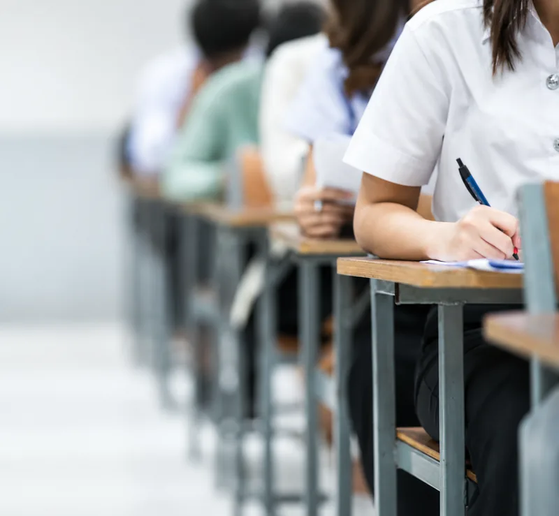 Rows of students writing an exam at desks