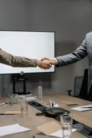 Two people shaking hands in a boardroom