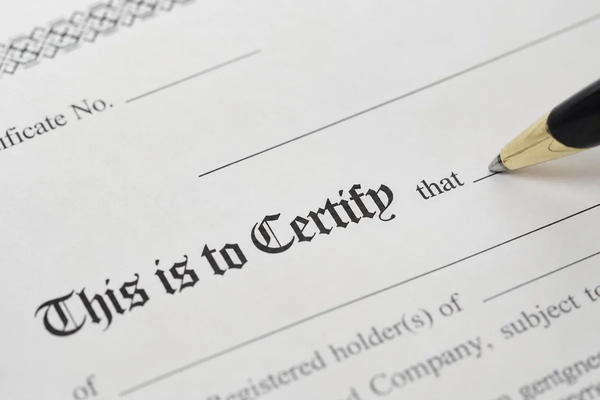 A pen resting on a certificate that reads This is to Certify